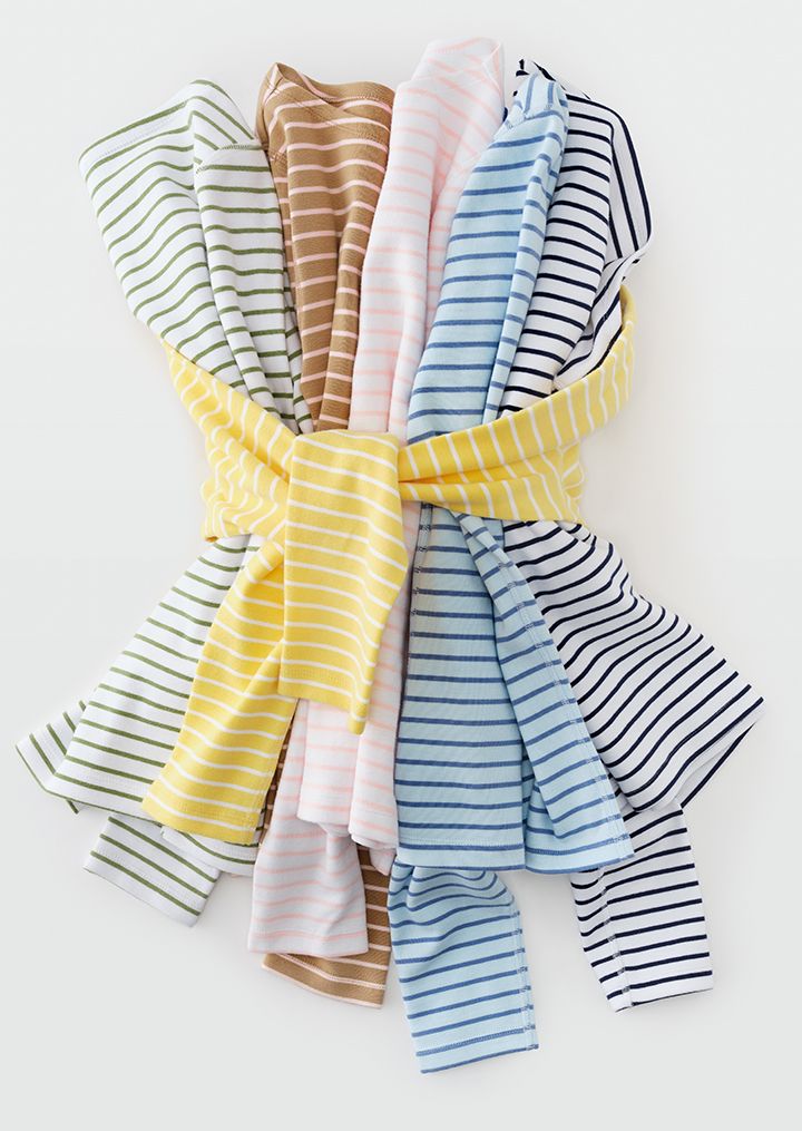 A bundle of folded, striped t-shirts in various colors, tied with a yellow striped fabric.