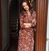 woman standing in doorway wearing burgundy and navy swirl pattern wrap dress