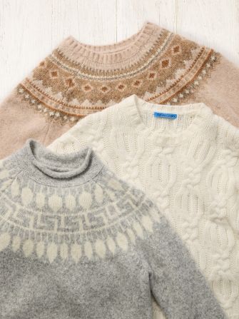 group of womens winter sweaters in a laydown