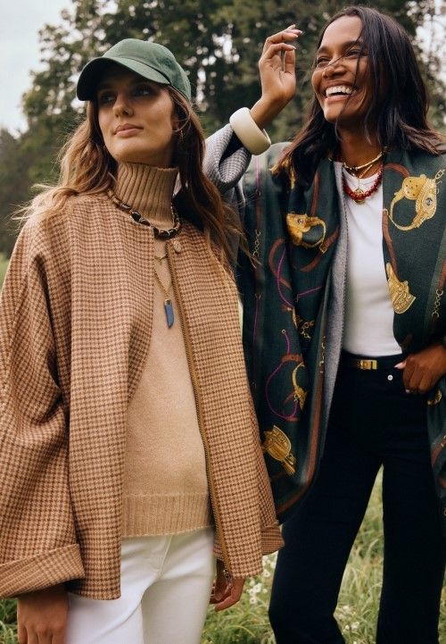two woman standing outside in a field wearing wool houndstooth capes