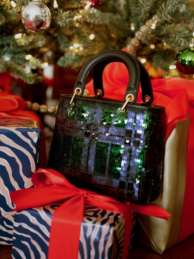 sequin mini bag positioned atop presents and near christmas tree