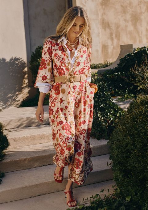 Woman in tan and coral and pink printed dress