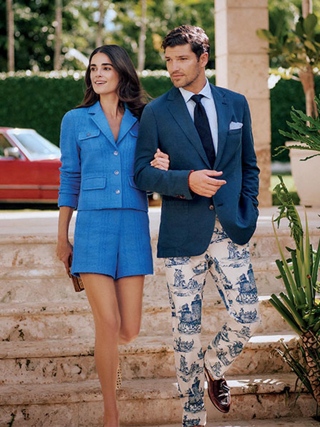 Female model in tweed shorts suit and male model in blazer and printed pants