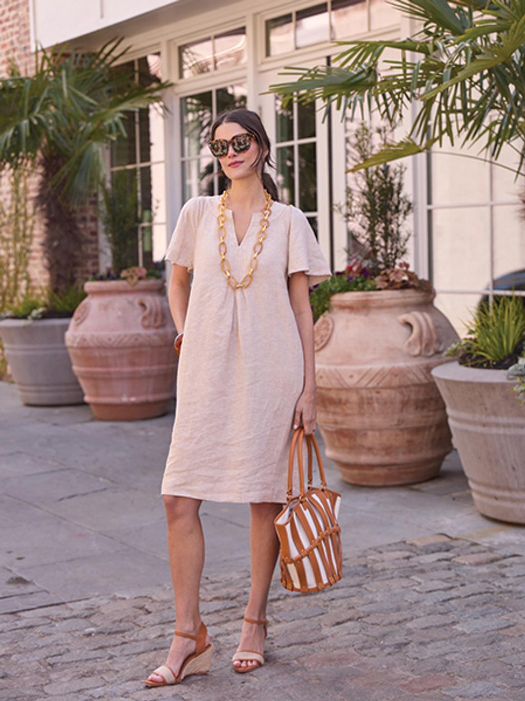 Model in neutral dress in front of Pinch Hotel