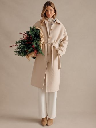 woman standing wearing beige winter coat