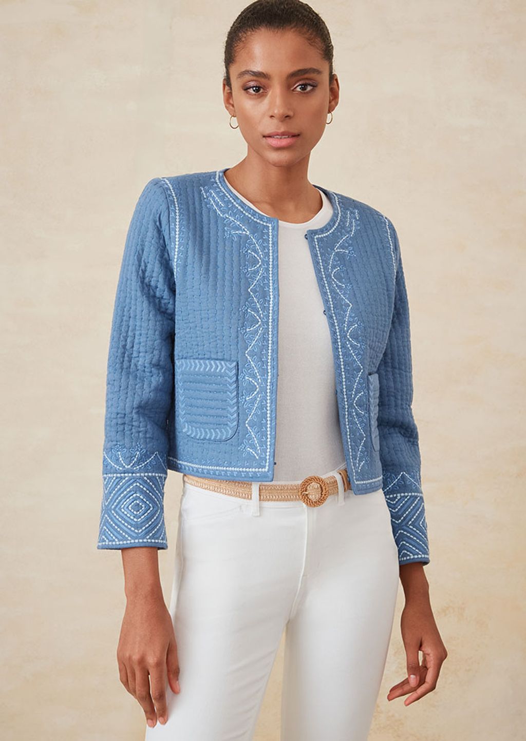 Woman wearing a 3/4 sleeve blue floral belted dress with Raffia flats.
