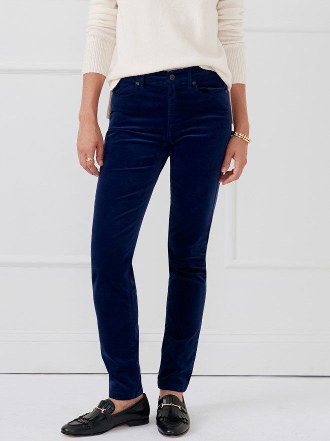 woman standing in dark blue velveteen slim leg jeans