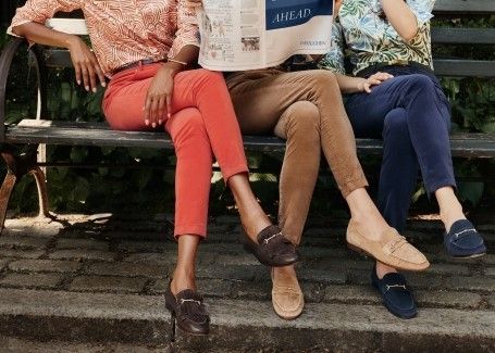 trio of women on a park bench wearing different color velvet jeans and loafers