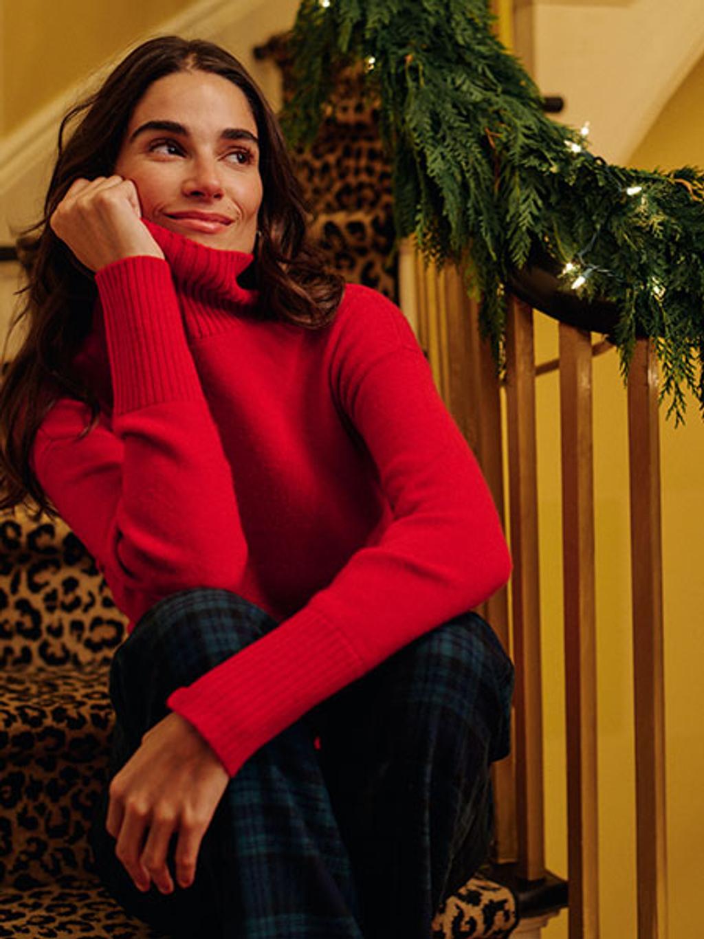 Model wearing a bright red turtleneck sweater.