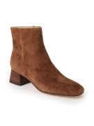 still life image of tan suede short stack heel ankle boot