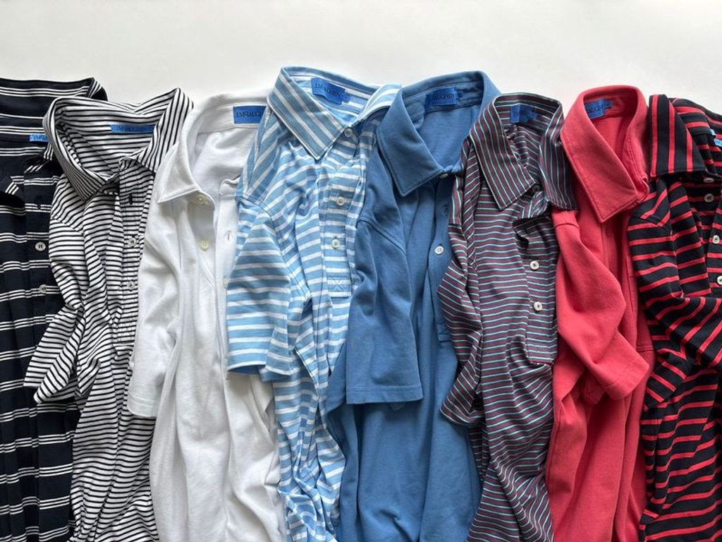 A range of colorful polo shirts, including solids and stripes, laid side by side.