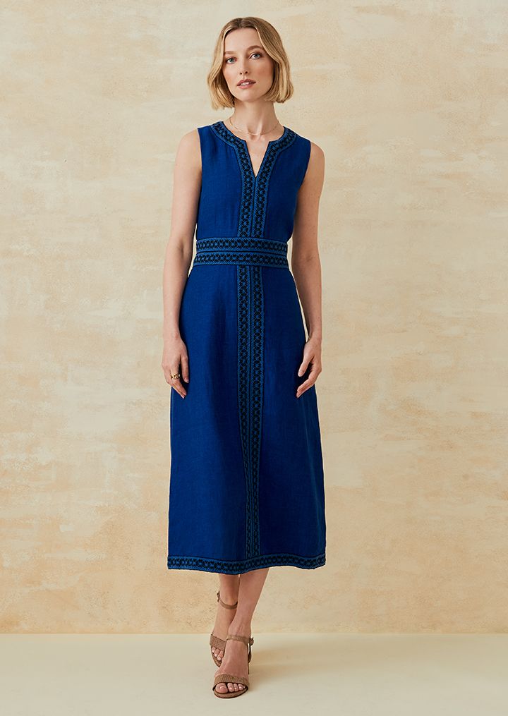 Woman standing in a denim colored linen maxi dress.