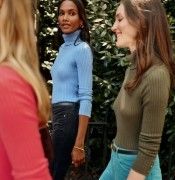 trio of women walking outside wearing various color turtlenecks and velveteen jeans
