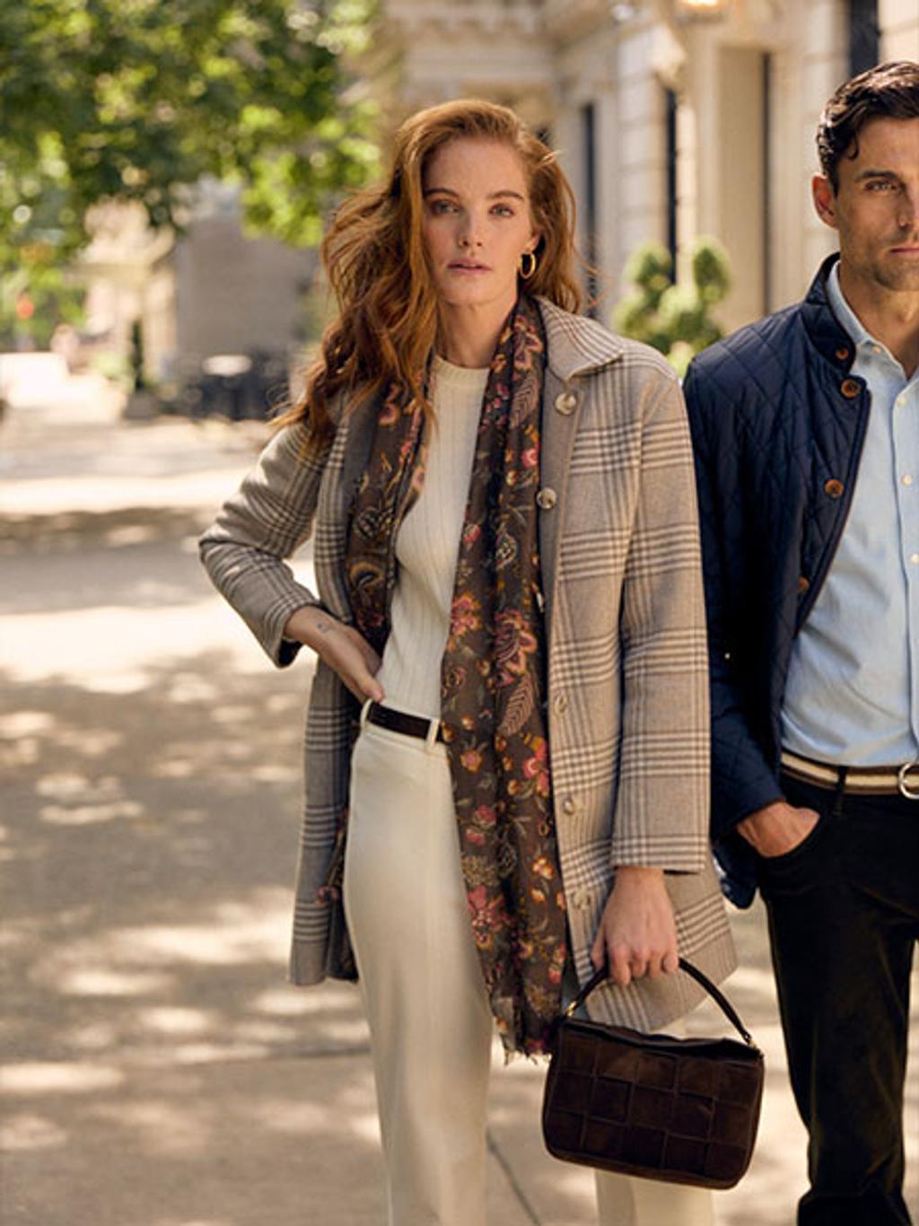 Model wearing plaid wool coat, slacks, and a handbag.
