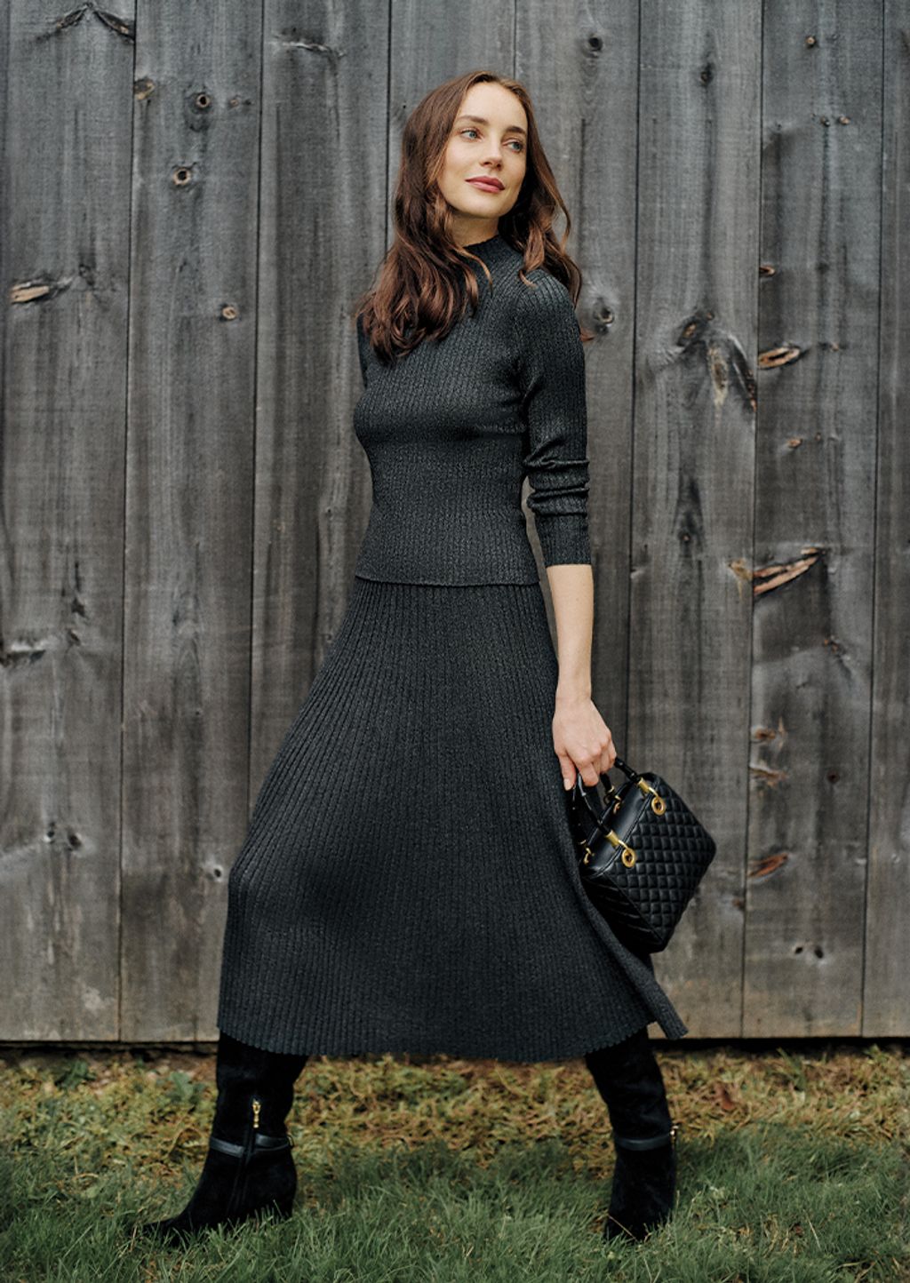 Woman wearing a black/metallic matching skirt and sweater.