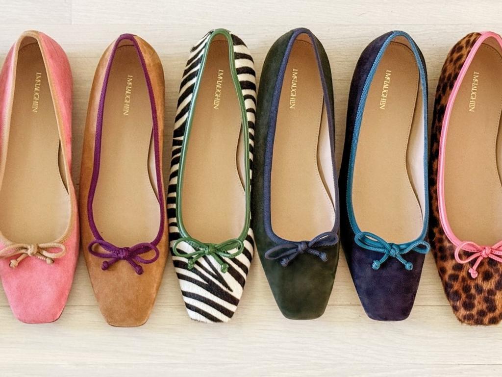 Six ballet flats in pink, tan, zebra print, dark green, dark blue, and leopard print, each with a decorative bow, lined up.