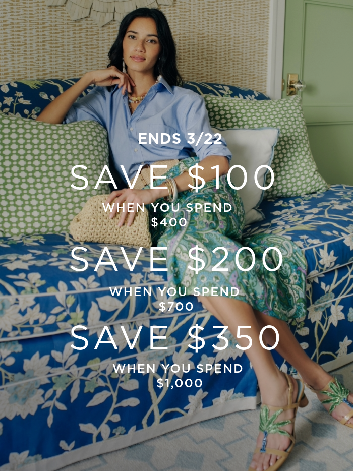 woman seated in sofa in paisley skirt and blue button down shirt