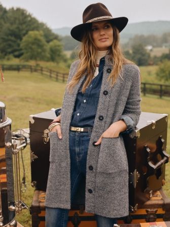 woman on farm wearing gray long sweater coat over denim
