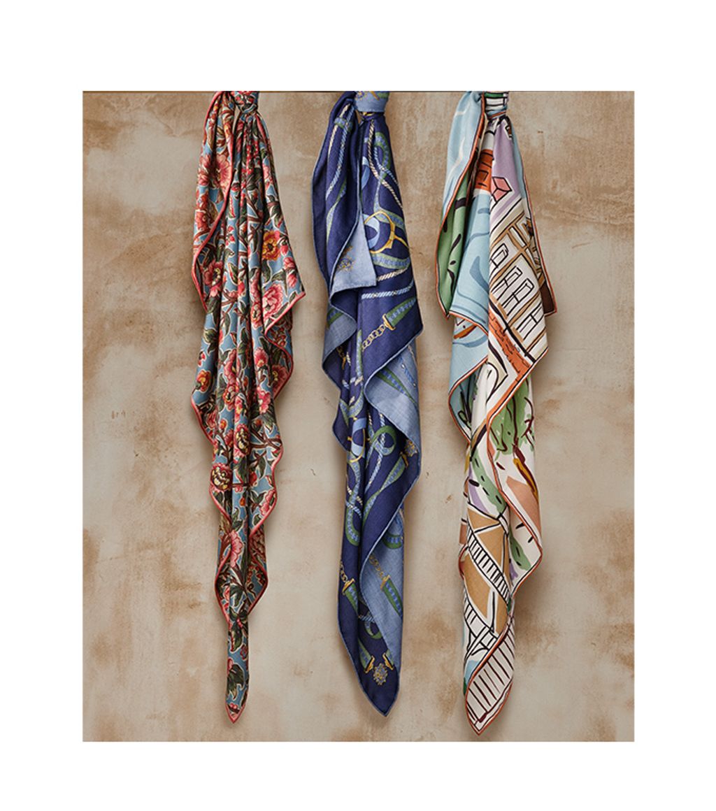 group of womens oversized scarves in various patterns tied around a hang bar
