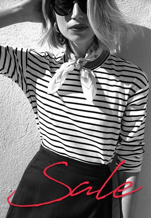 black and white image of woman in striped shirt with red cursive sale headline overlayed