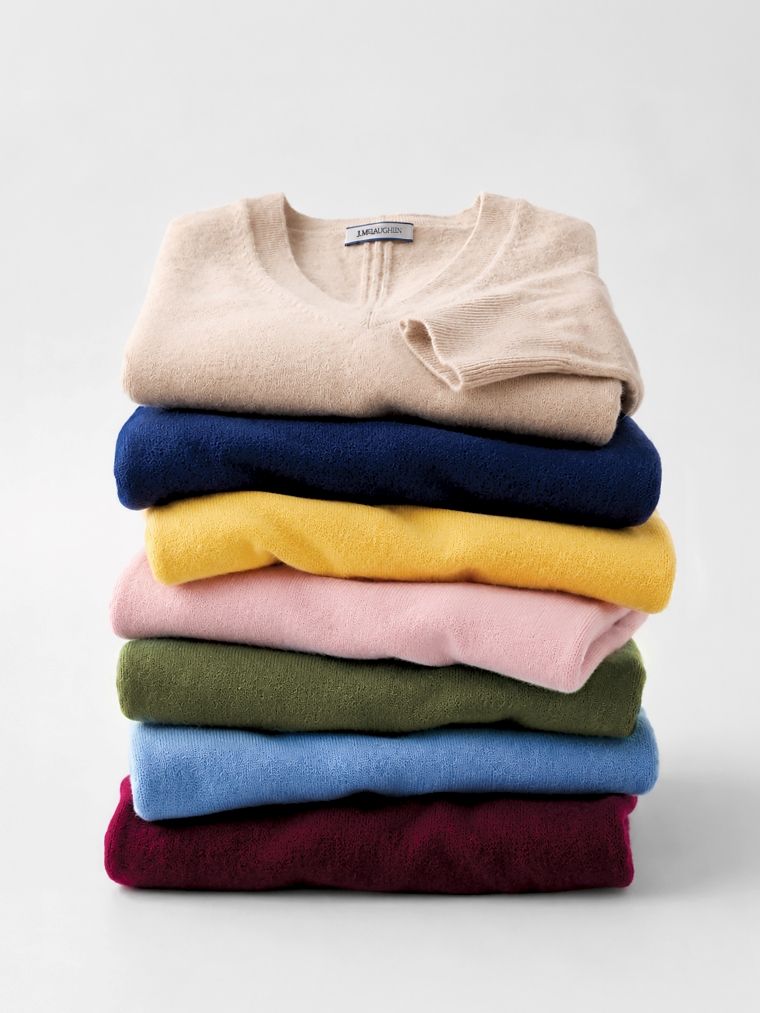 A neatly folded stack of colorful sweaters.