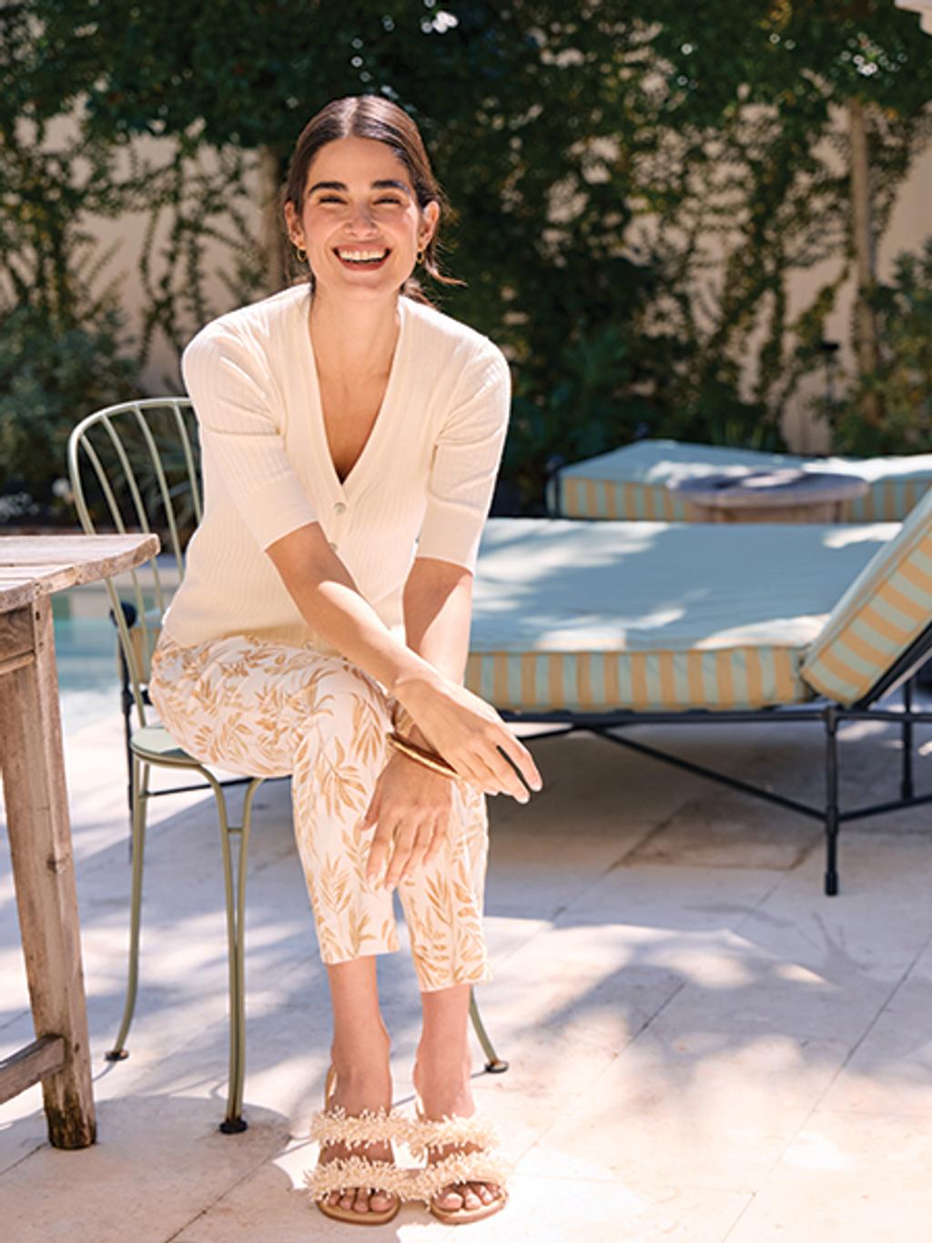 Model in cardigan and printed pants in backyard