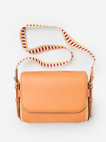 Tan leather crossbody handbag with wicker detail and decorative strap. 