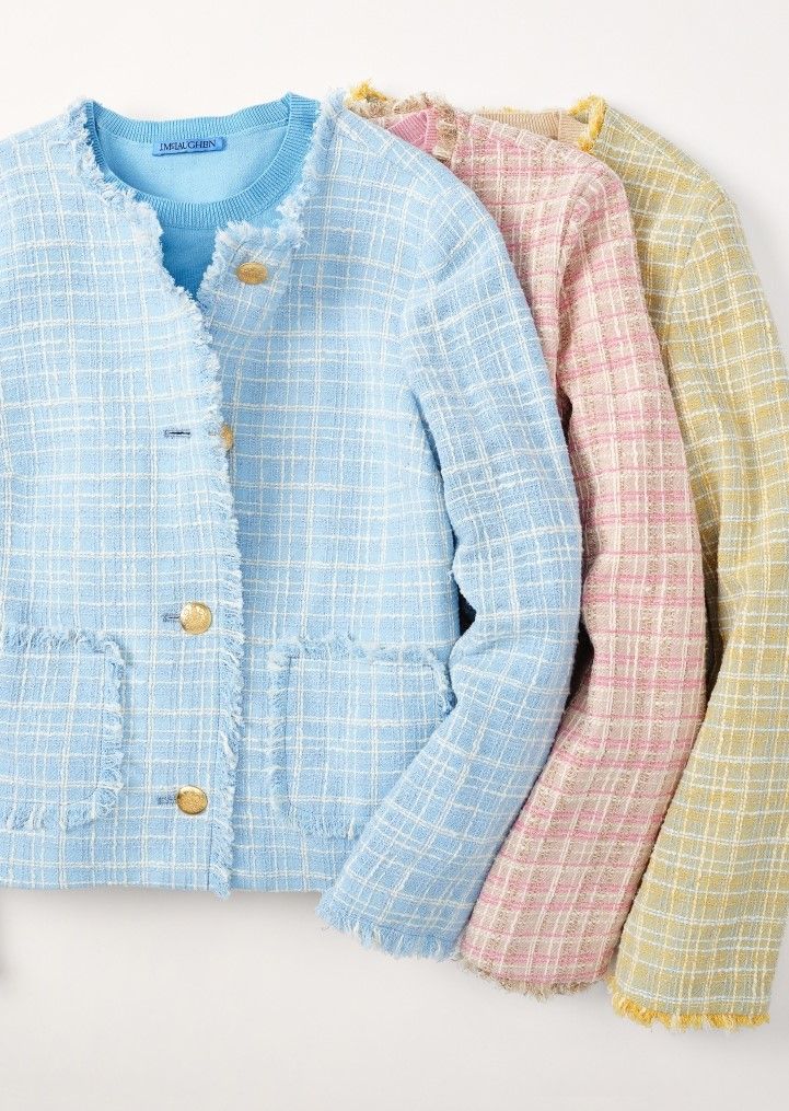 Three pastel plaid blazers with gold buttons and fringed edges, in blue, pink, and yellow.