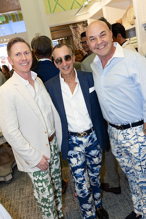 Three men pose together for photo