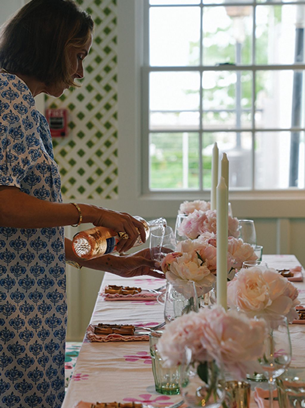 Filipa de Abreu in floral dress setting the table
