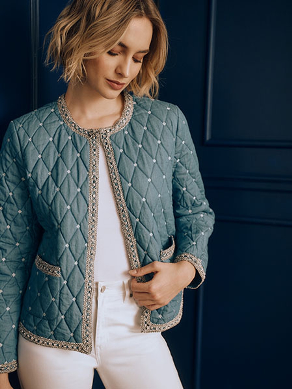Model in collarless quilted jacket and white jeans