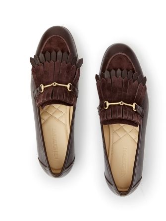 still life of womens brown leather loafers with bamboo bit hardware