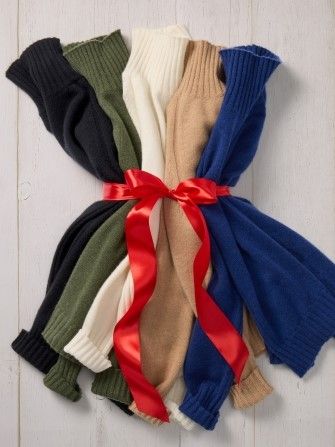 laydown of womens cashmere turtleneck sweaters tied together with a red bow