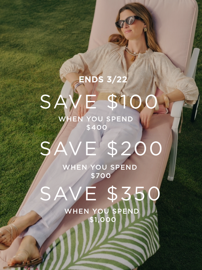 woman laying on lounge chair wearing tan blouse and white linen pants