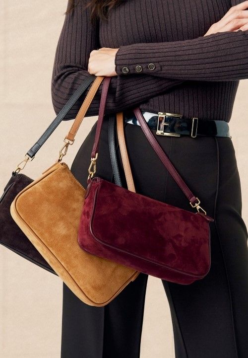 cropped in image of suede zip top small shoulder bags draped across womans arm
