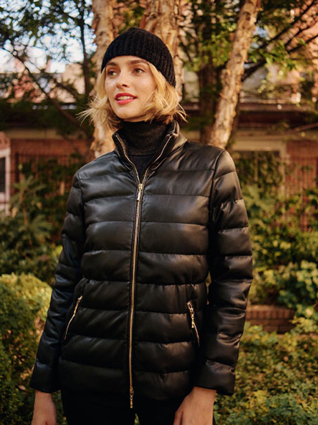 Model wearing a black puffer jacket and beanie.
