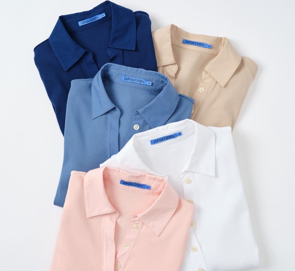 Five folded collared shirts in dark blue, light blue, beige, white, and pink.