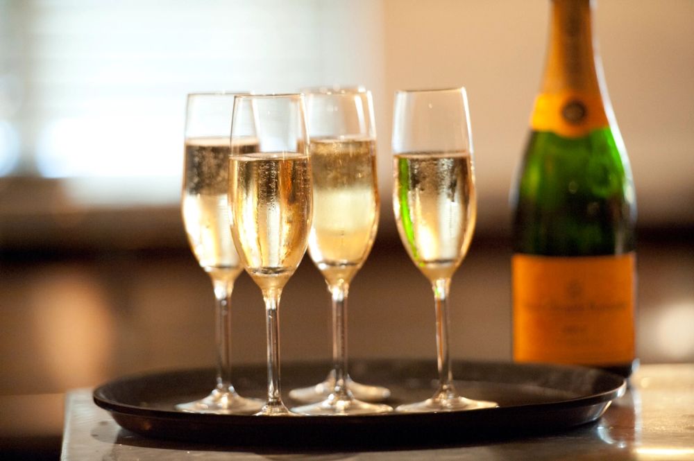 Champagne poured into flutes beside the bottle on a tray
