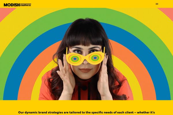 Creative agency website — bold, maximalist serif design in bright yellow and rainbow colors. "Our dynamic brand strategies are tailored to the specific needs of each client."