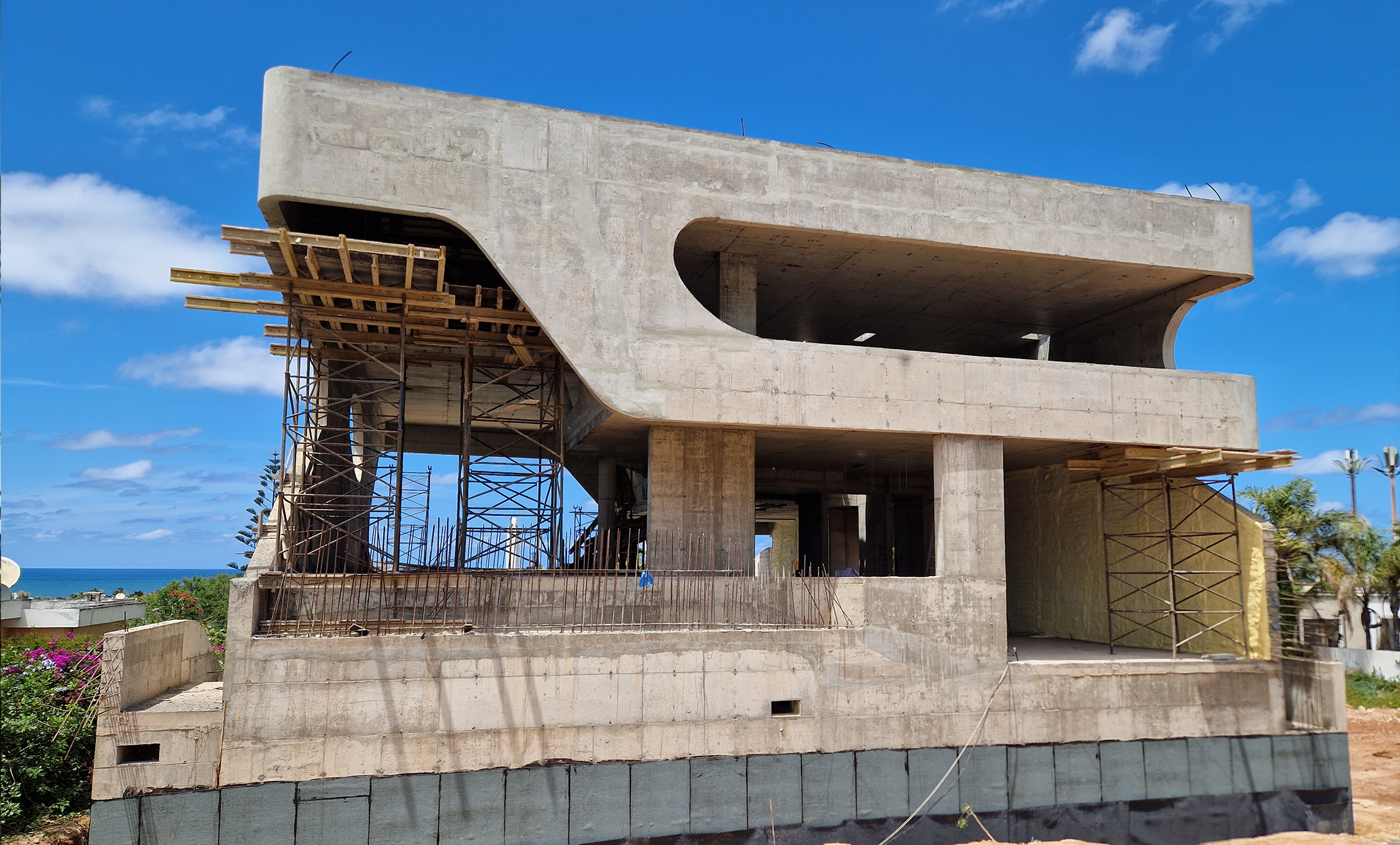 Ansicht Baustelle, man sieht im Rohbau die geschwungen Formen der Fassade
