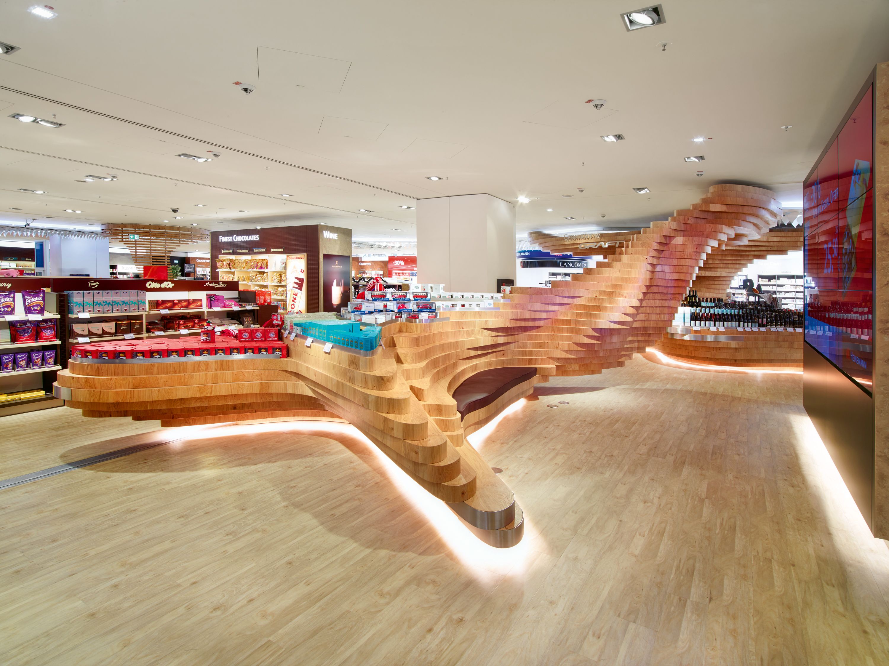 With this modern interpretation of the forest, GRAFT has created an open and fluid space, a clearing in which passengers can pause for a while amid the hustle and bustle of the airport terminal.