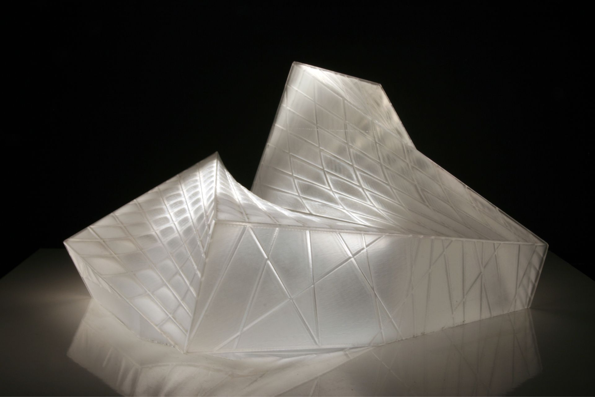 This crystalline envelope shelters the visitor without cutting him or her off from the surrounding landscape. As a mental space for prayer rather than an isolated enclosure, the landscape is of essential atmospheric importance and is invited to interact with the building’s interior. The technological functions necessary for a modern theatre are submerged in the ground so that the stage can be used flexibly for a range of purposes.