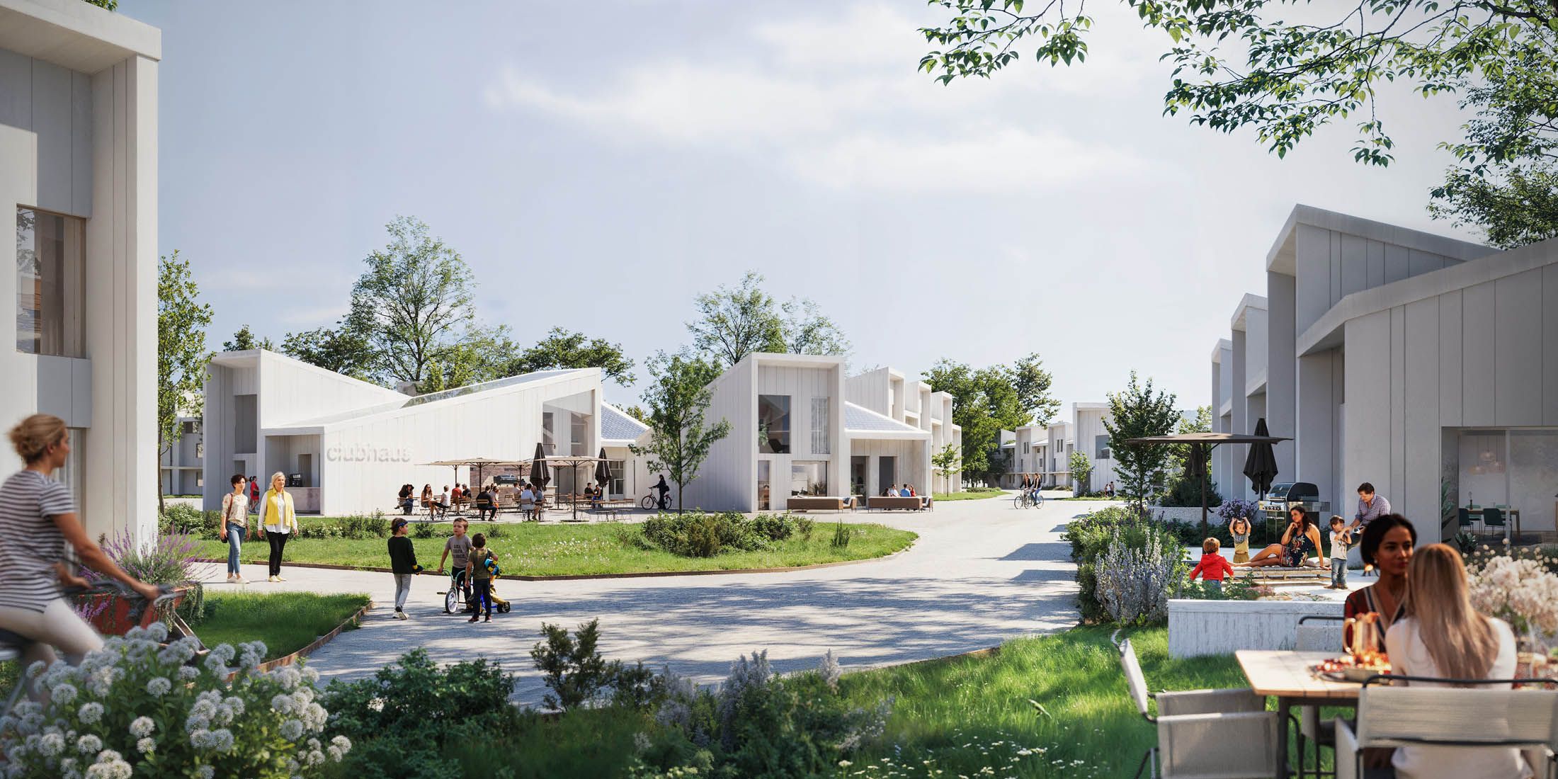 Modern residential area with white houses, people walking and sitting outdoors, and green lawns under a partly cloudy sky