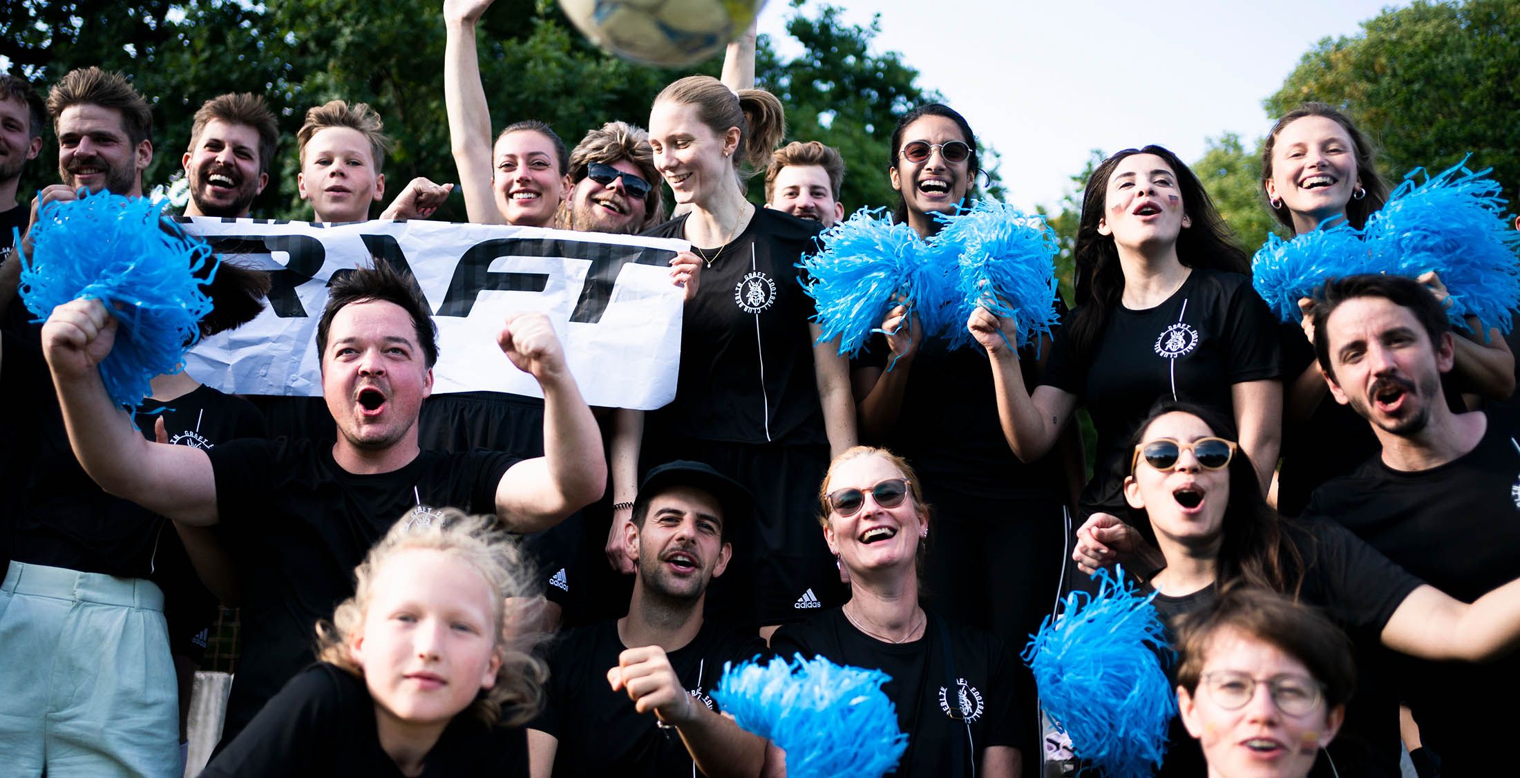 Employees of GRAFT cheering at a football game