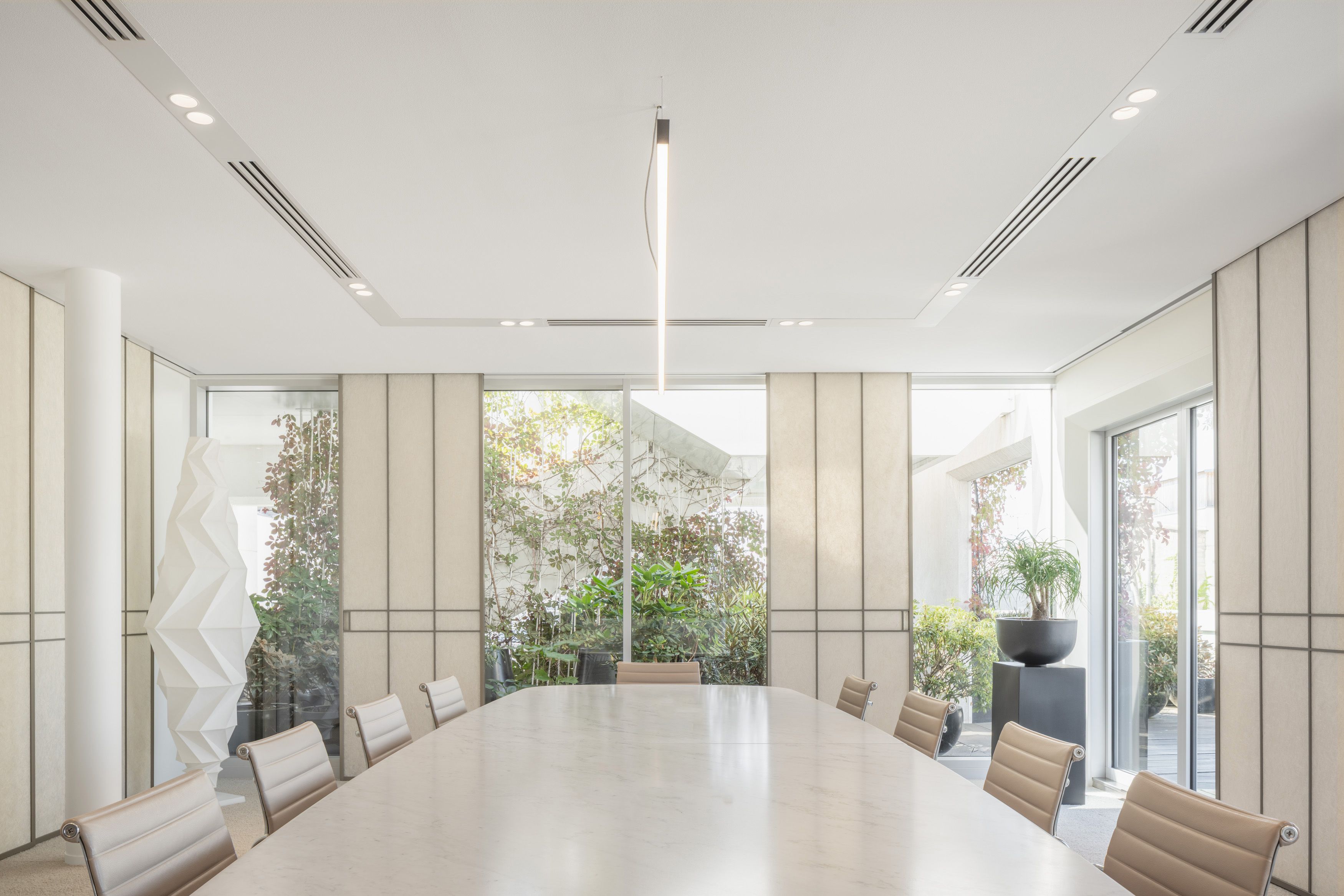 The same conference room with large windows showing outdoor plants