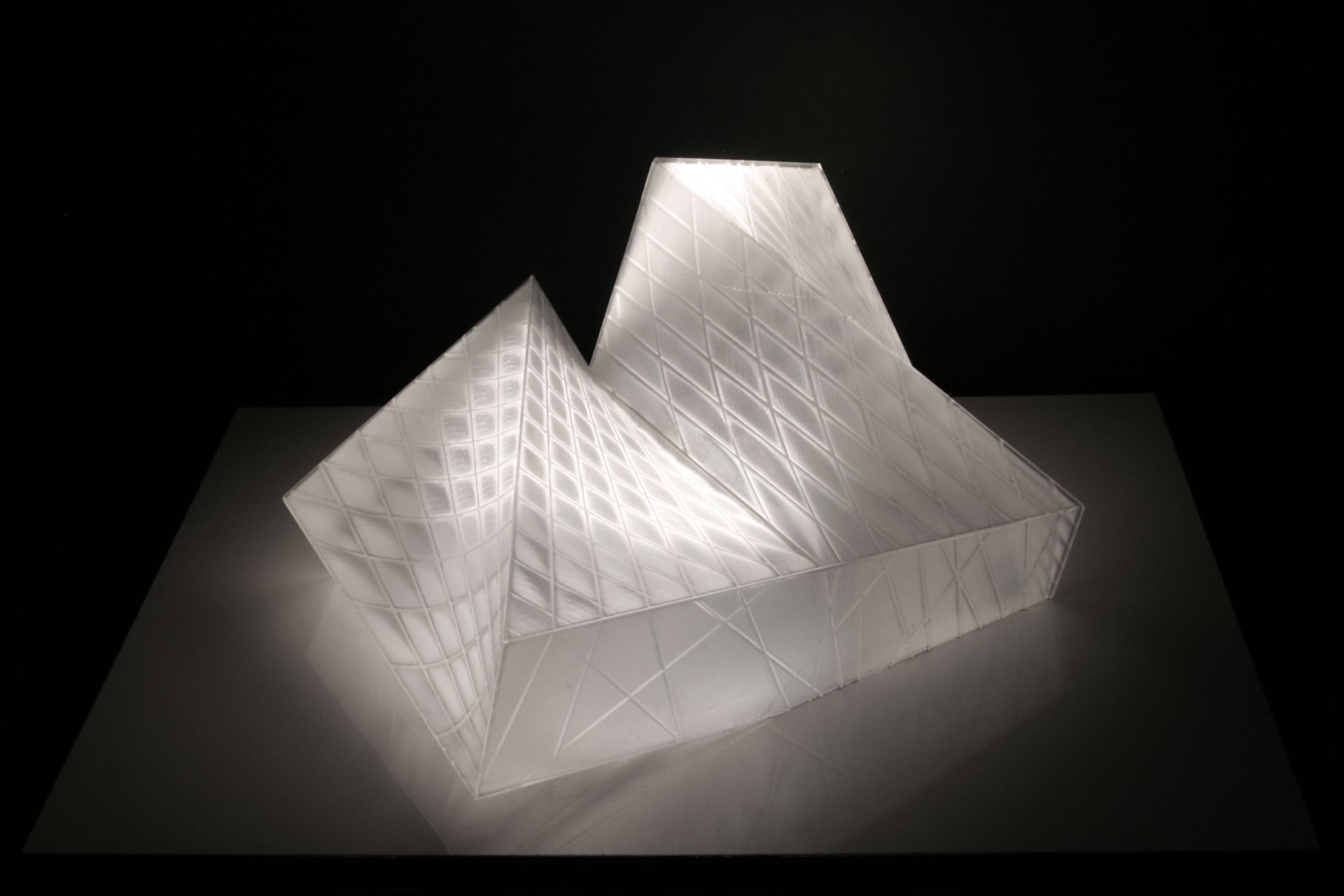 This crystalline envelope shelters the visitor without cutting him or her off from the surrounding landscape. As a mental space for prayer rather than an isolated enclosure, the landscape is of essential atmospheric importance and is invited to interact with the building’s interior. The technological functions necessary for a modern theatre are submerged in the ground so that the stage can be used flexibly for a range of purposes.