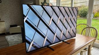 Телевизор Sony Bravia 7 с диагональю 55 дюймов и разрешением 4K на деревянном обеденном столе рядом с дверями на террасу