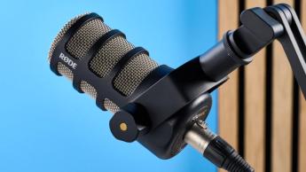 Rode PodMic Podcast- und Rundfunkmikrofon auf blauem Hintergrund mit Rode DS2 Tischständer