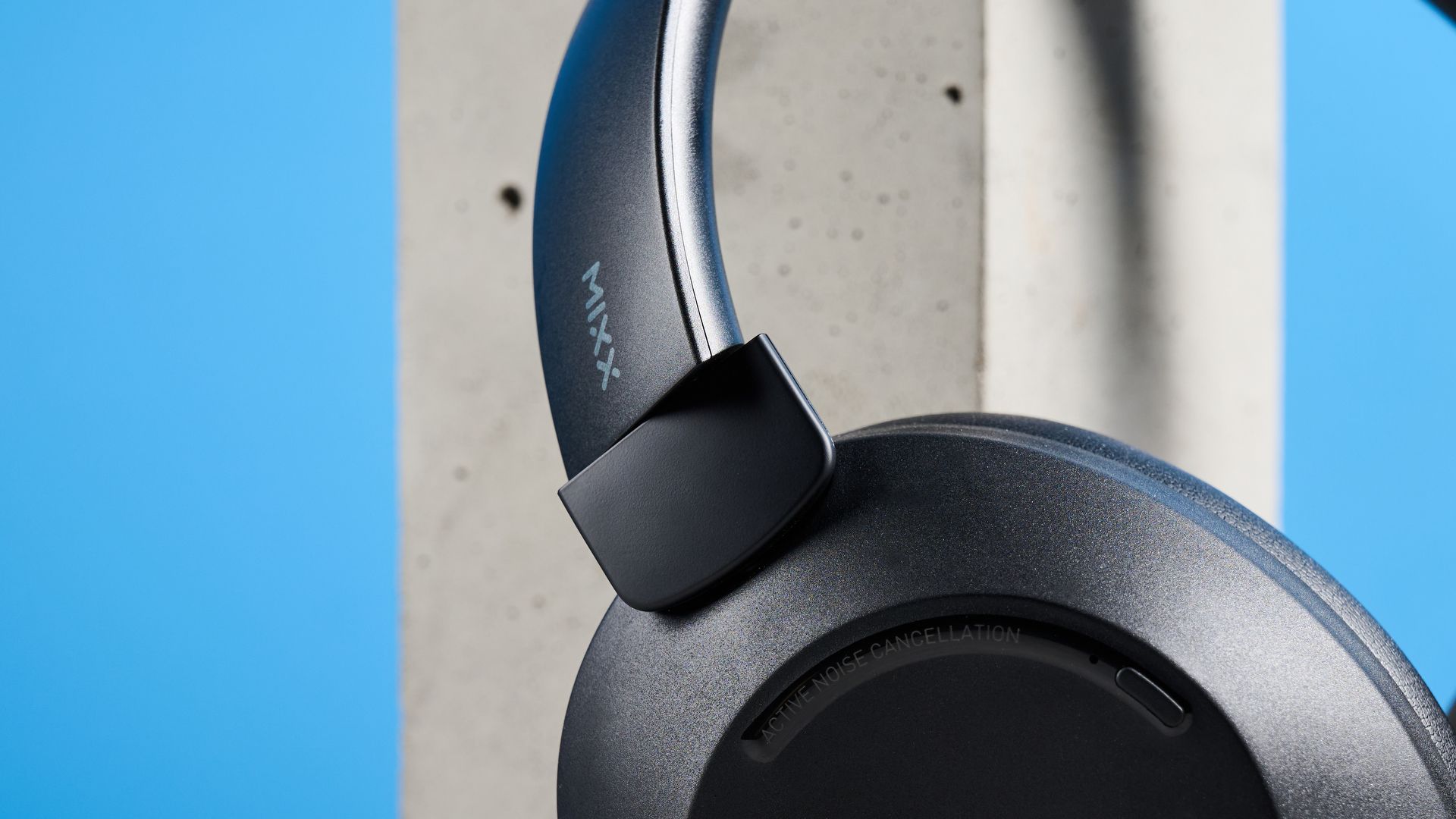 Mixx StreamQ C4 kabellose Kopfhörer in Schwarz mit weichen Ohrpolstern und Tastensteuerung vor blauem Hintergrund