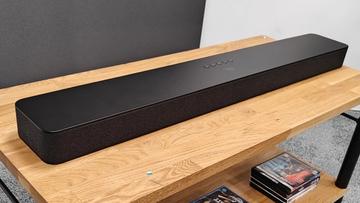 Звуковая панель Amazon Fire TV с технологией Dolby Atmos на деревянной мультимедийной стойке